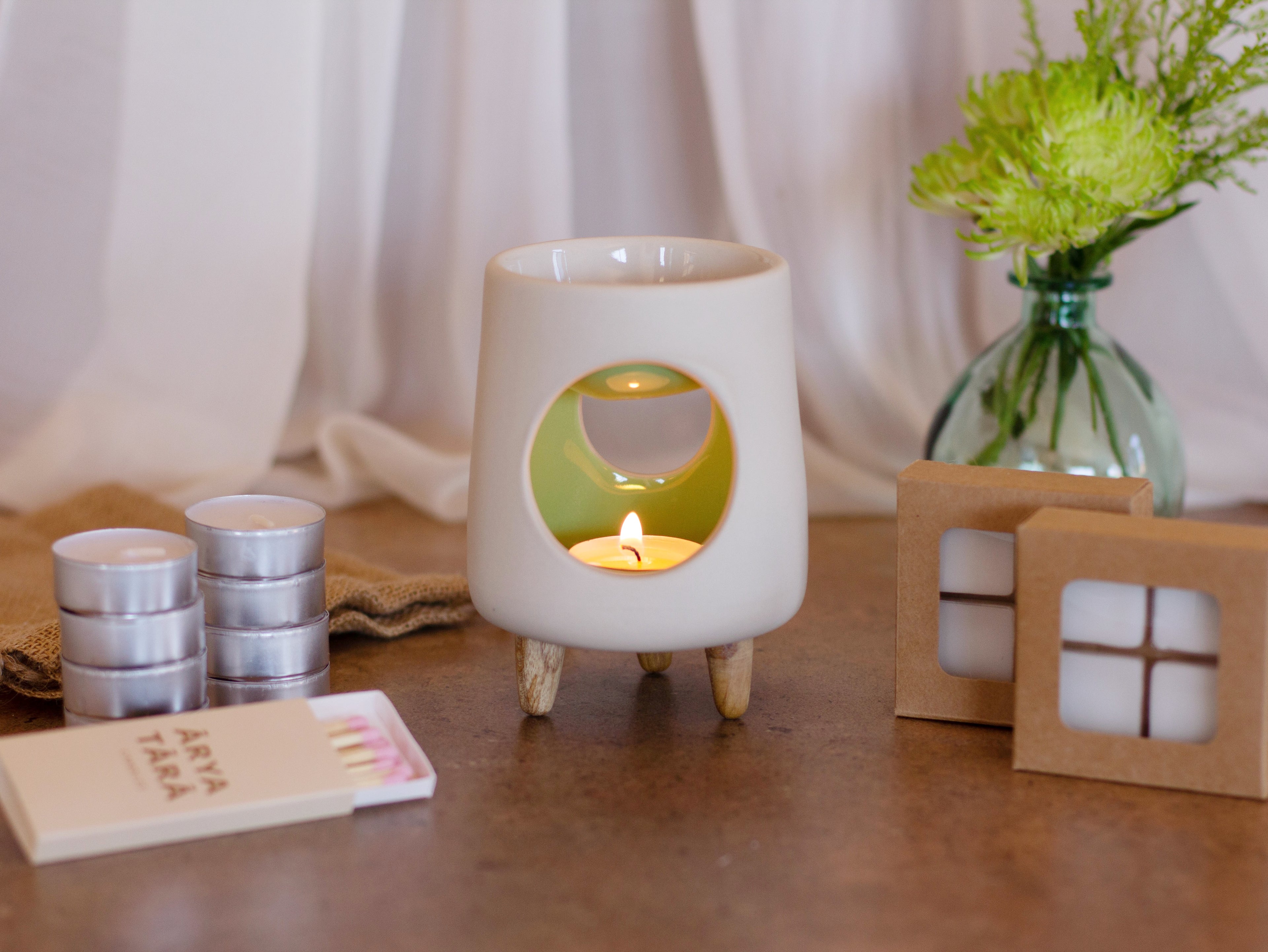 Ceramic wax warmer essential oil warmer by Arya Tara Candles. White outside green inside colored. Ceramic handmade tealight wax warmer with wooden legs.