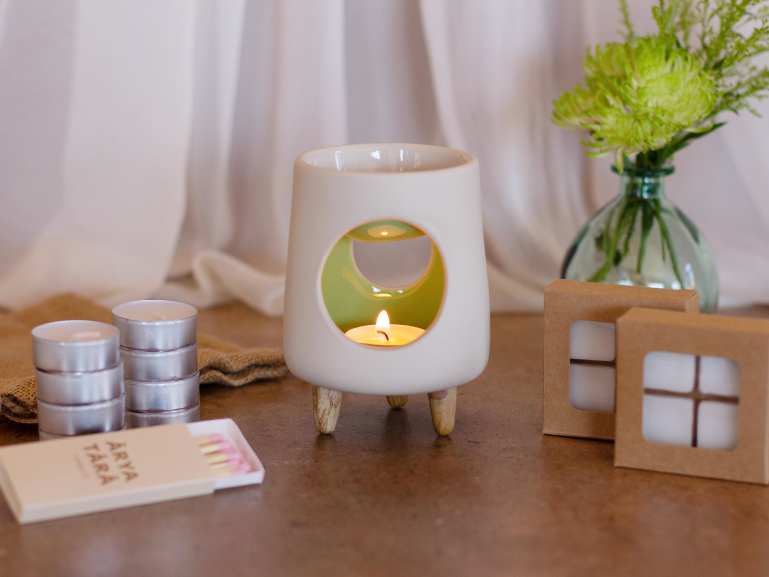 Ceramic wax warmer essential oil warmer by Arya Tara Candles. White outside green inside colored. Ceramic handmade tealight wax warmer with wooden legs.